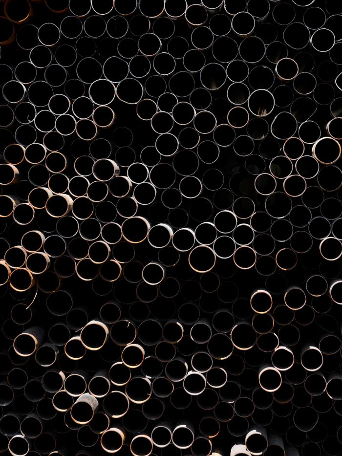 Close-up of stacked metal tubes creating a repetitive geometric pattern.