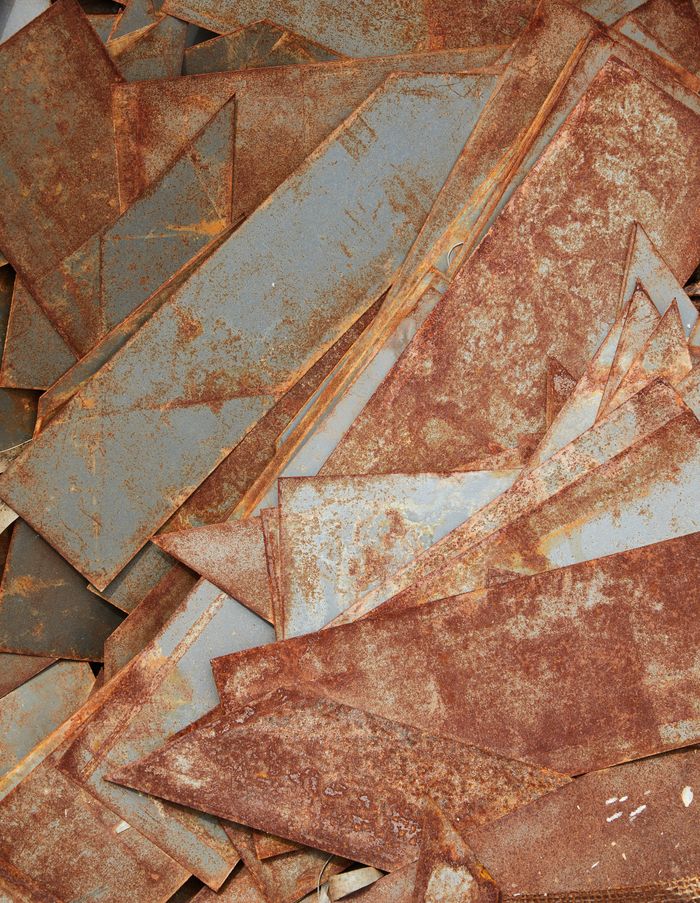 Top view of aged iron segments covered with rust placed in heap in workshop